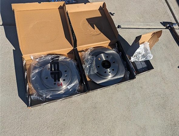 Close-up of worn brake pads being replaced by a certified technician for smooth, quiet braking.