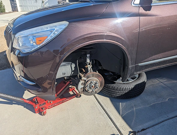 Mechanic using high-quality parts and professional tools during an on-site brake repair.