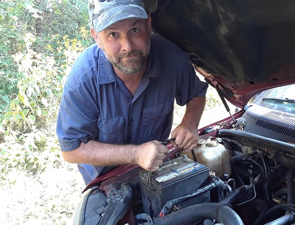 Allstar Mobile Mechanic technician installing a high-quality car battery in a customer's vehicle.