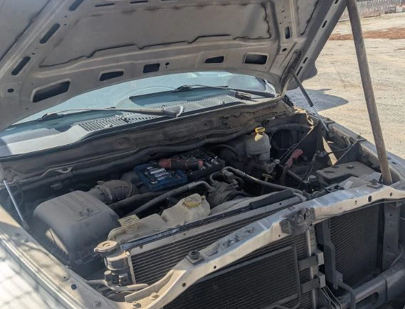 A car with an open hood showing tools on the engine block for quick radiator repair and cooling system maintenance in Salisbury, NC.